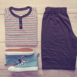 T-shirt with pants and shoes on wooden background - Vintage Filter